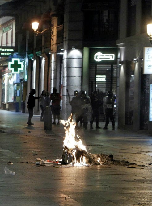 Antidisturbios controlan los accesos de la madrileña calle Preciados, donde algunos manifestantes han provocado pequeños incendios después de que se hayan registrado cargas policiales en la concentración espontánea que ha tenido lugar este miércoles en apoyo a los mineros y contra los recortes anunciados por el Gobierno en la Puerta del Sol.