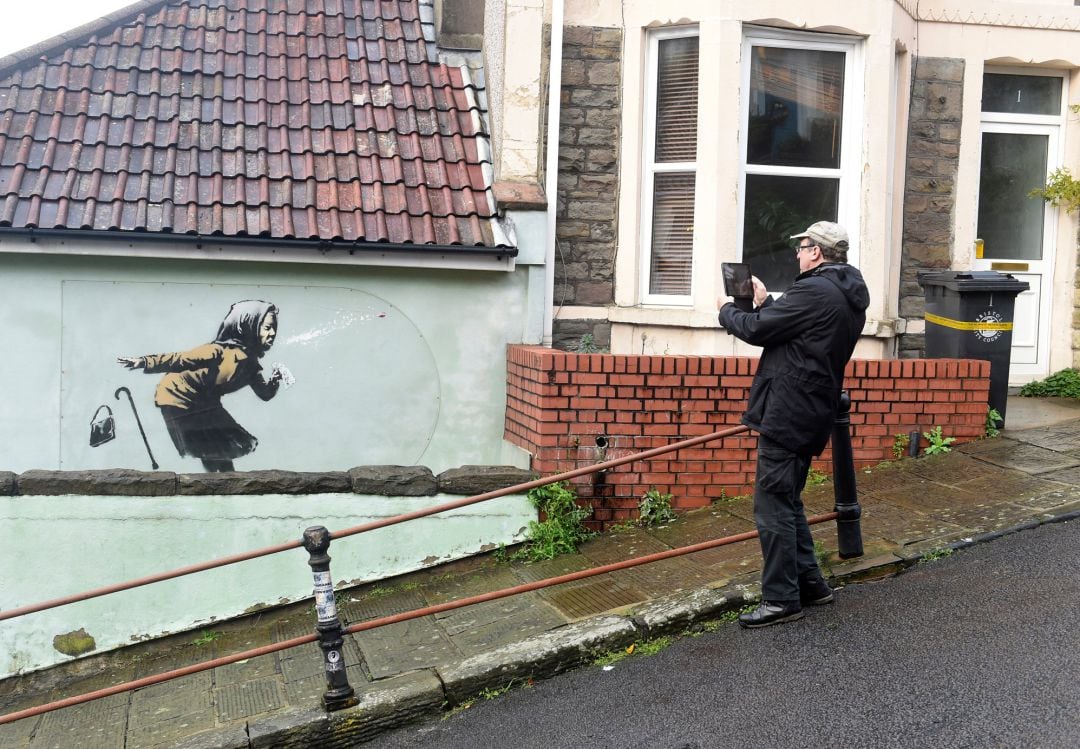 Un hombre fotografía la última obra de Banksy, llamada &#039;Aachoo!!&#039;, en Bristol (Reino Unido).