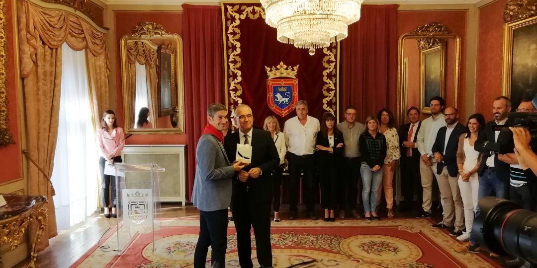 Enrique Maya haciendo entrega del Pañuelo de Pamplona y de la escultura a Alberto Undiano