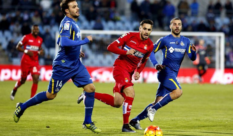 El defensa del Espanyol Roberto Correa (c) junto a los jugadores del Getafe, los centrocampistas Pedro León (i) y Mahdi Lacen (d), durante el partido de la vigésima jornada de liga en Primera División disputado esta tarde en el estadio Coliseum Alfonso Pé