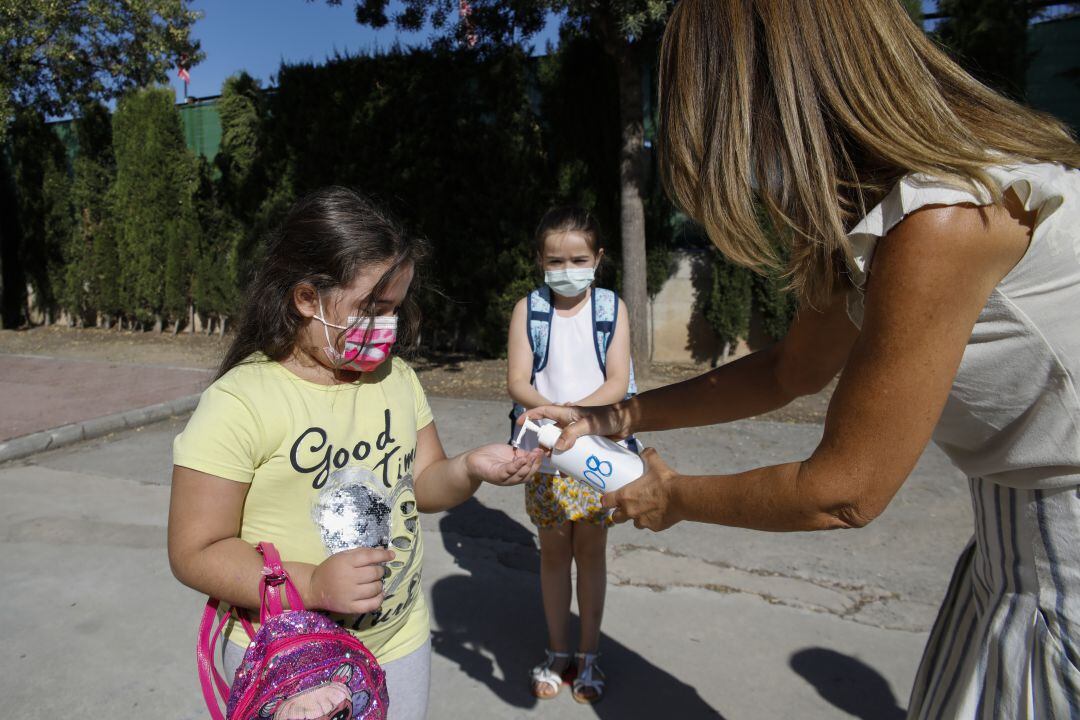 Niñas se desinfectan las manos con gel hidroalcohólico durante la pandemia de Covid-19