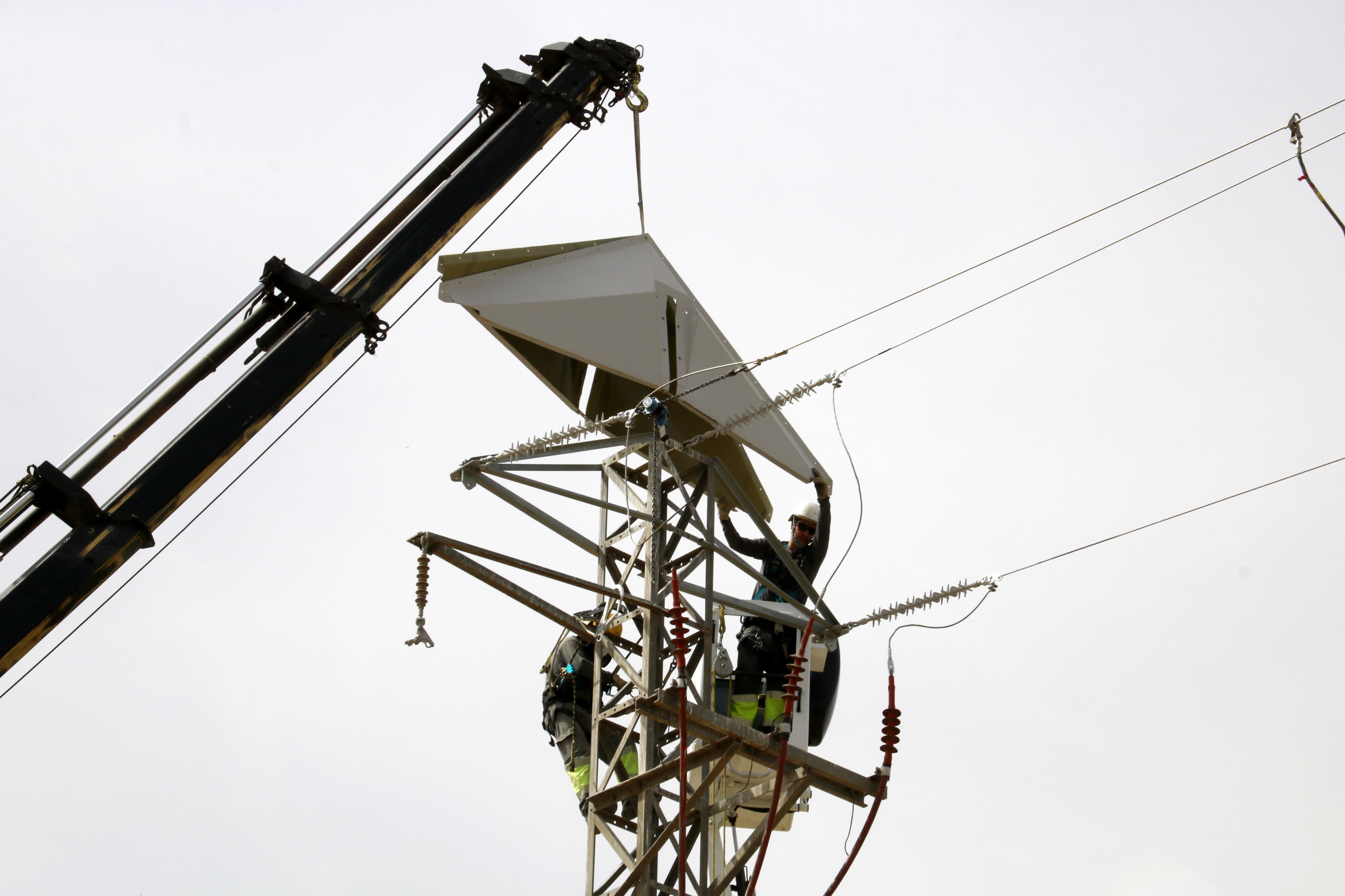 Operarios trabajando en una torre eléctrica.