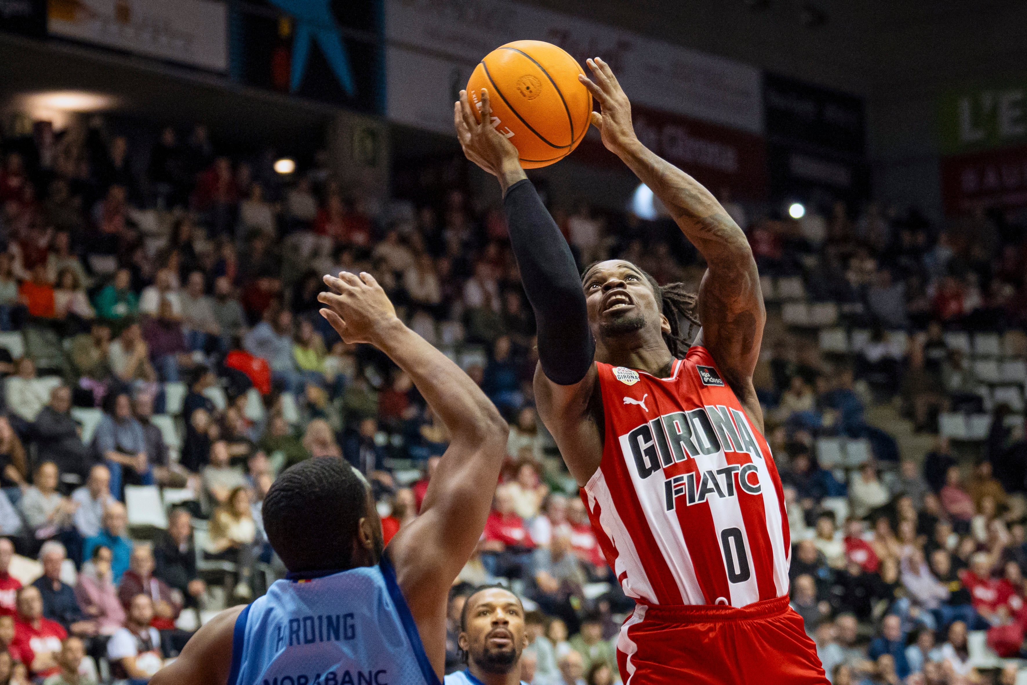 El base nigerià del Girona Ike Iroegbu (d) llença a cistella davant el nord-americà del MoraBanc Andorra, Jerrick Harding, durant el partit de la Lliga Endesa disputat aquest dissabte al pavelló de Fontajau.