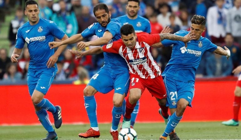 El centrocampista argentino del Atlético de Madrid Ángel Correa (2ºd) disputa el balón con los defensas del Getafe, el marroquí Faysal Fajr (2ºi) y Sergio Mora (d), durante el partido de Liga de primera División, correspondiente de la jornada 37, que disp