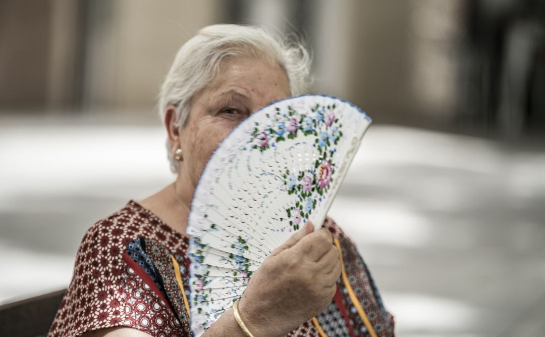 Una mujer abanicándose