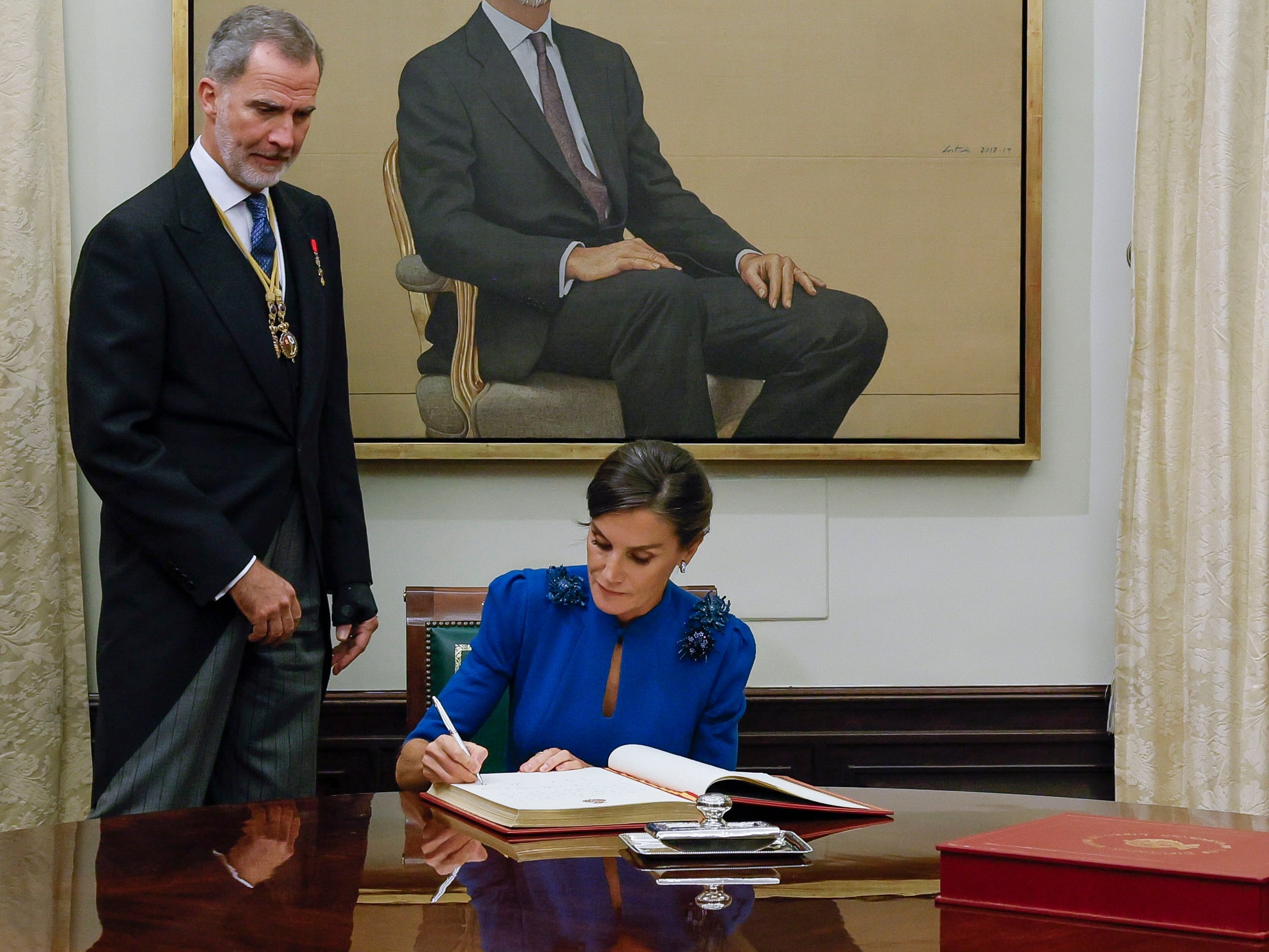 La reina Letizia (d), junto al rey Felipe VI (i), firma el libro de honor del Congreso.