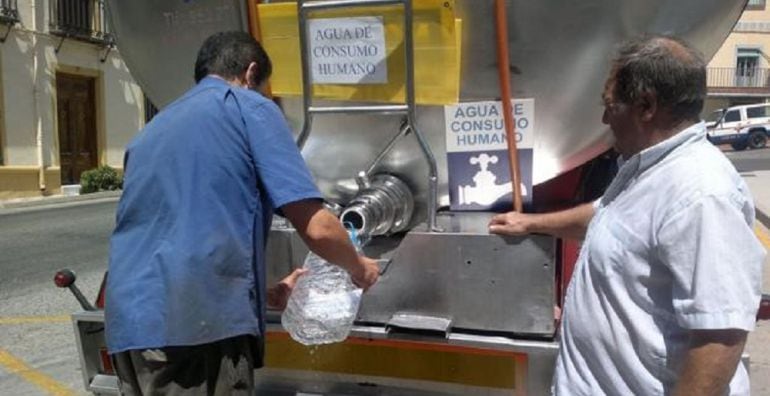 Un vecino del Condado recoge agua de un camión cisterna.