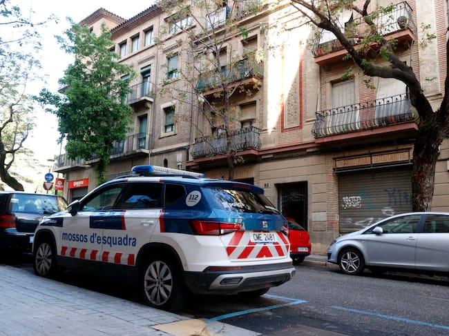 Un vehicle dels mossos aparcat al davant de l'edifici del carrer Valentí Almirall on van passar els fets. Foto: ACN.