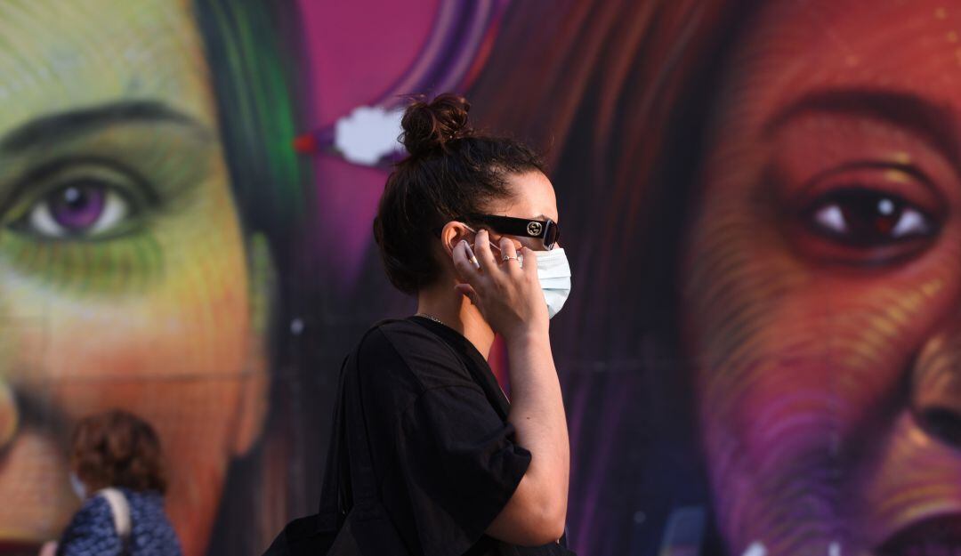 Una mujer pasea por la Gran Vía de Madrid con su mascarilla.