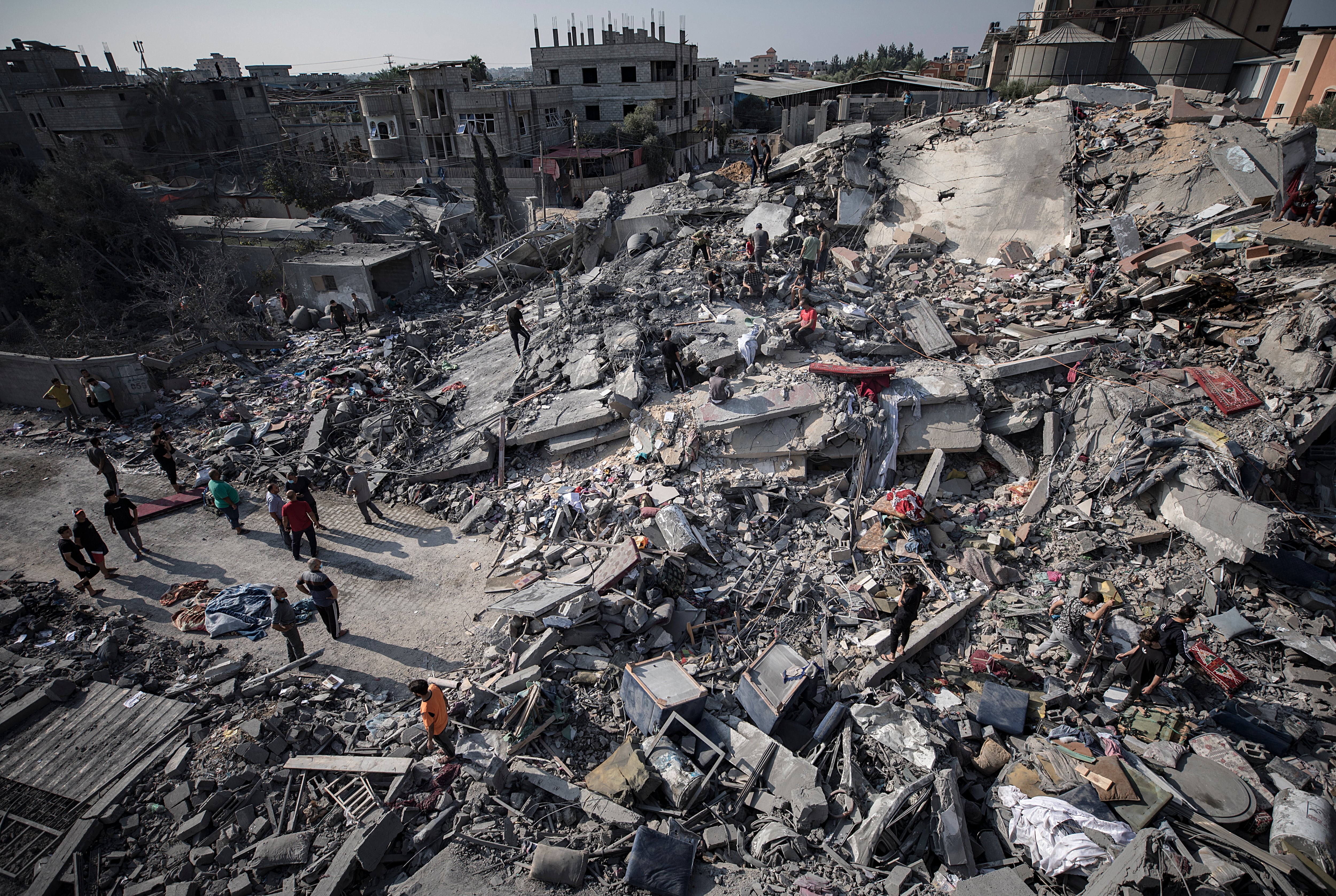 Los palestinos buscan cadáveres y supervivientes bajo los escombros de un edificio residencial tras un ataque aéreo israelí contra el campo de refugiados de Nuseirat, en el centro de la Franja de Gaza