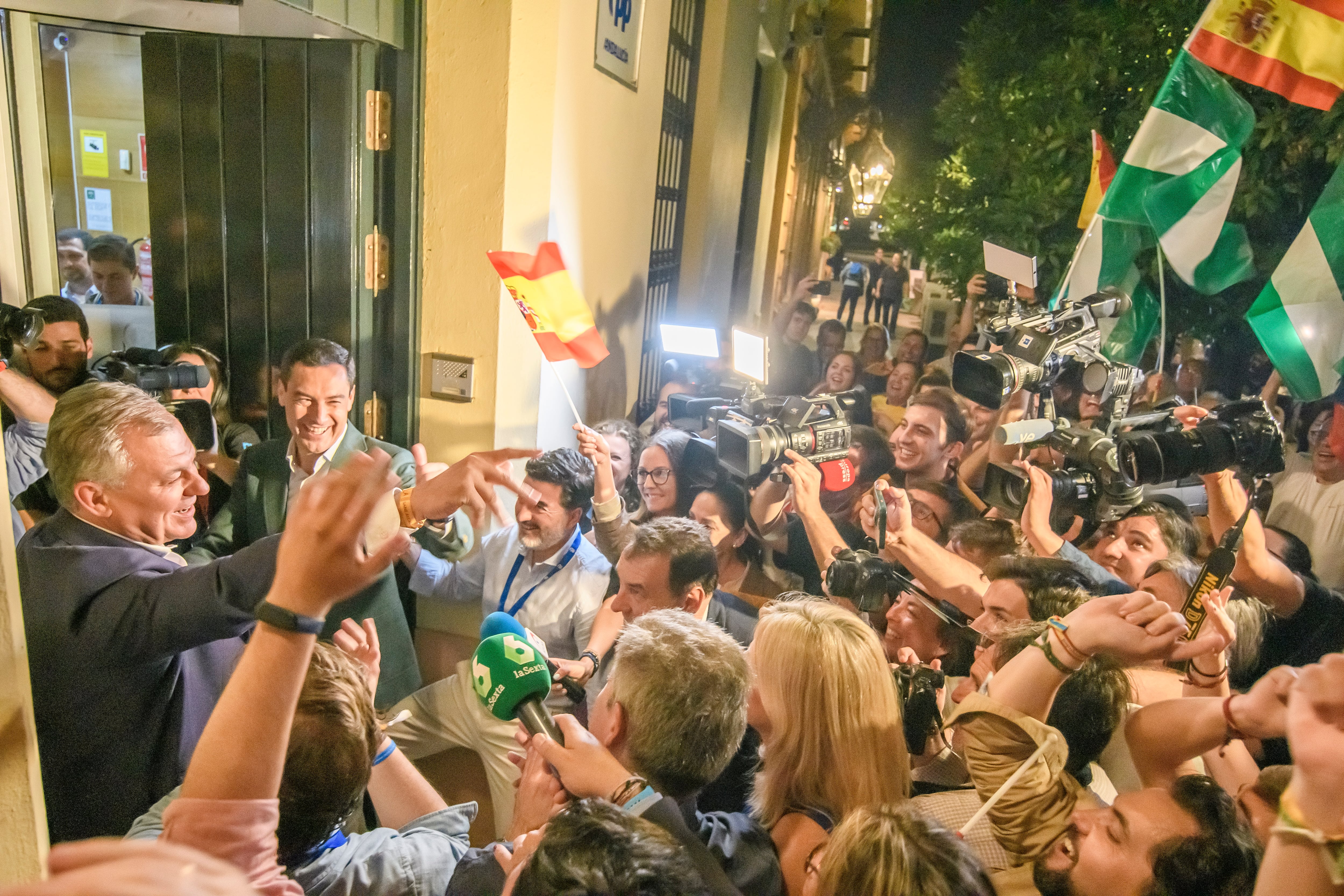 GRAFAND2252. SEVILLA, 29/05/2023.- El candidato a la alcaldía de Sevilla, José Luis Sanz (i). y el presidente del PP andaluz, Juanma Moreno (c), celebran la victoria en la puerta de la sede regional del partido en Sevilla. EFE/ Raúl Caro.
