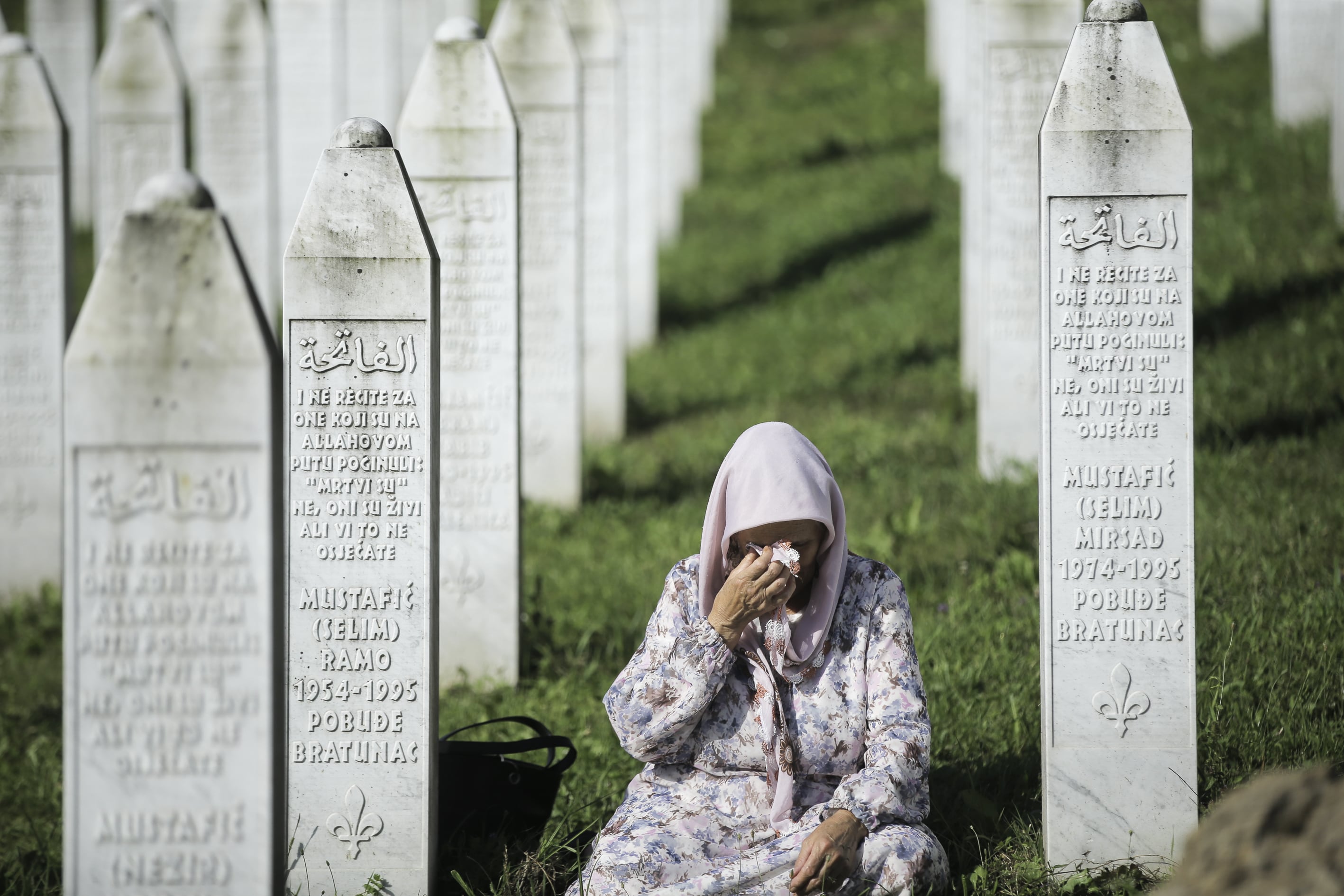 Una mujer llora entre las tumbas de las víctimas de la masacre de Srebrenica que descansan en el cementerio de Potocari