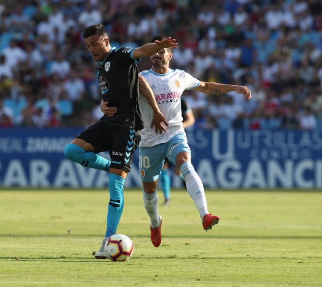 Javi Ros, que vuelve tras su lesión, sujeta a un jugador del Lugo en el partido de la primera vuelta en La Romareda