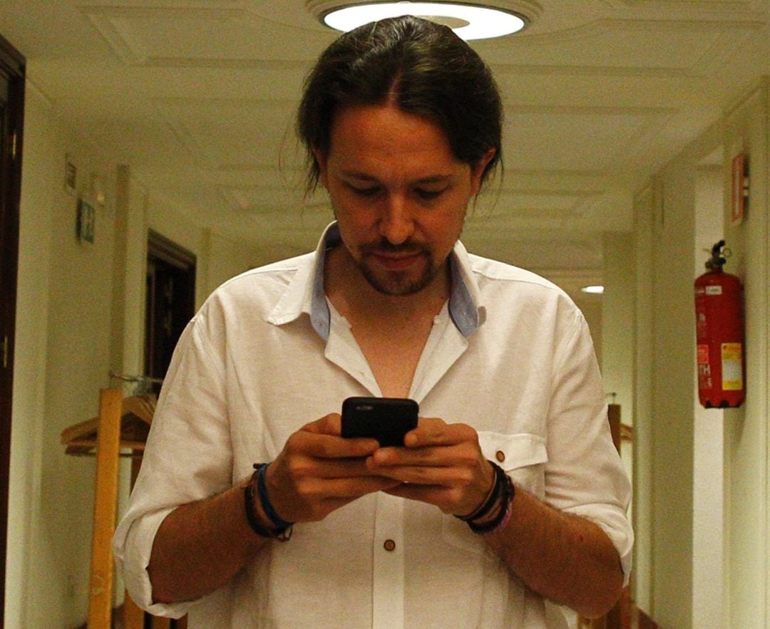 Pablo Iglesias, secretario general de Podemos, con su teléfono móvil. 
 