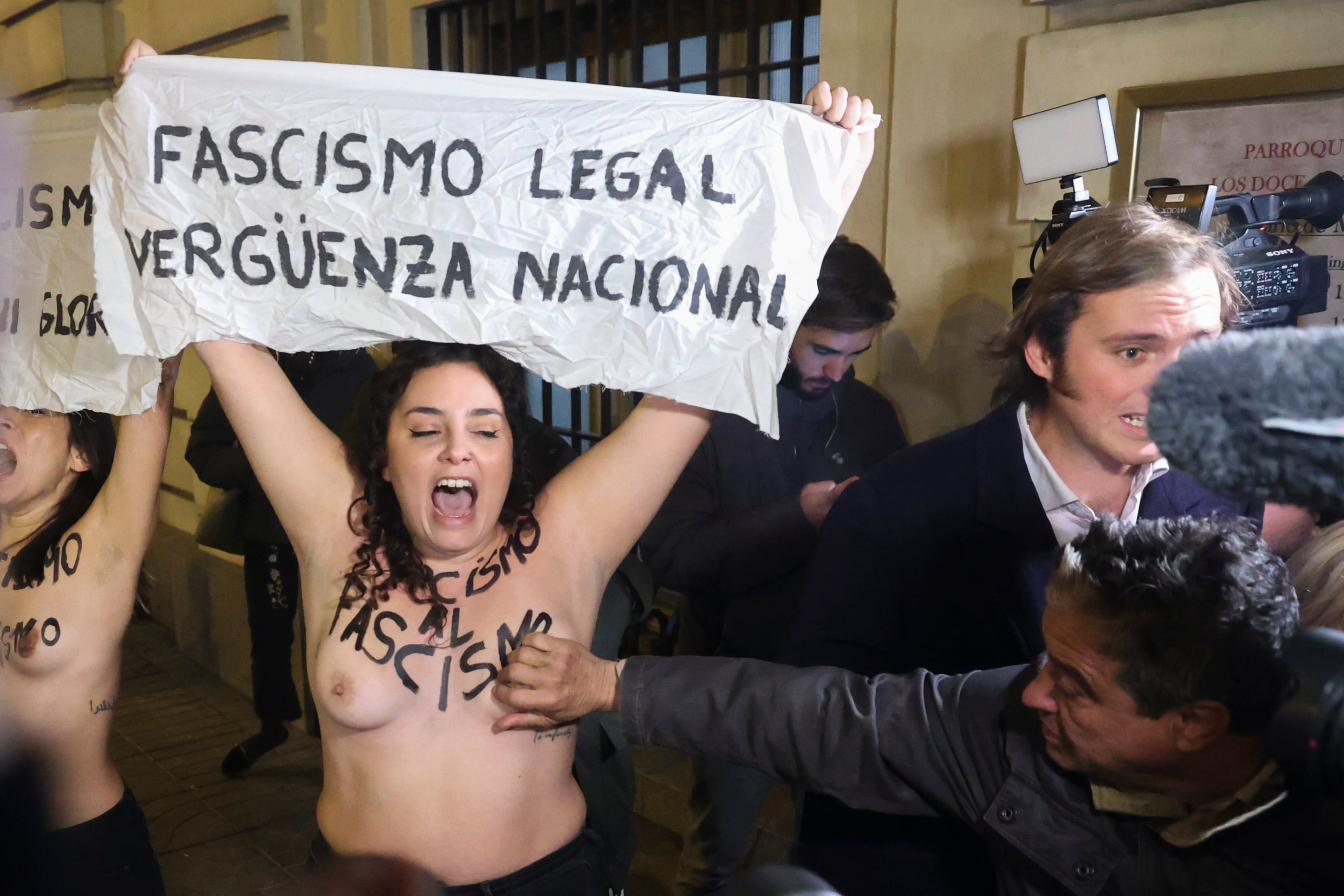Un hombre toca el pecho a una de los dos activistas de Femen que protestan semidesnudas con motivo de la misa organizada por la Fundación Francisco Franco  EFE/Víctor Lerena