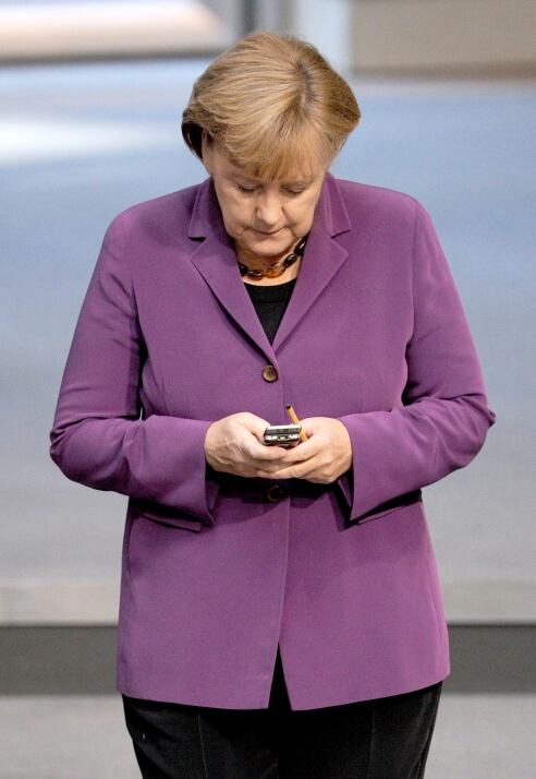 La canciller alemana Ángela Merkel mira su teléfono en la Parlamento de Alemania en una fotografía de archivo