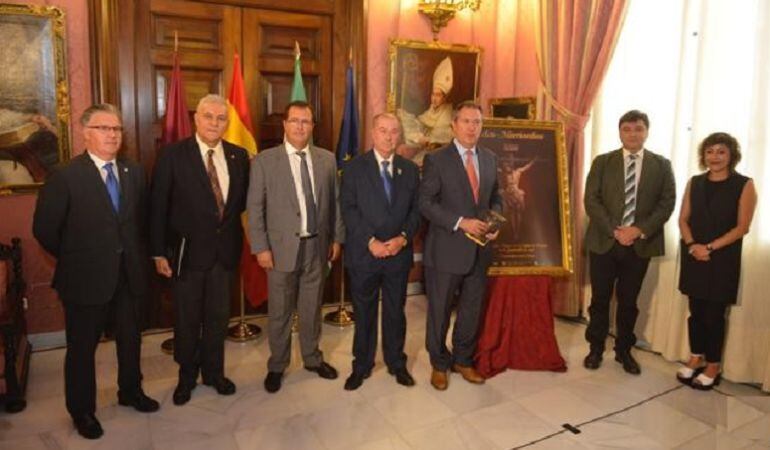 Los alcaldes de Sevilla y Huelva, Juan Espadas y Gabriel Pérez, flanquean en el Ayuntamiento de Sevilla el cartel de la Procesión Magna que se celebrará este sábado día 17 en la capital onubense