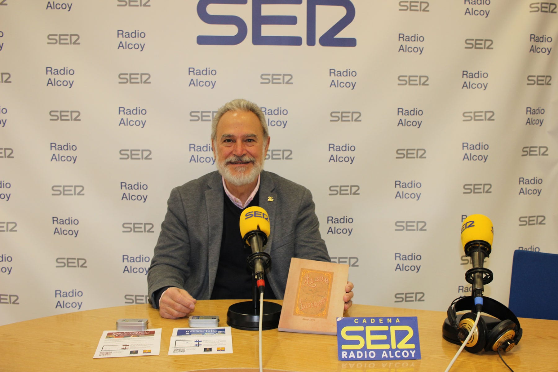 Indalecio Carbonell, en el estudio central de Radio Alcoy con un ejemplar del libro reeditado  de 1876 y los usbs con las revistas digitalizadas