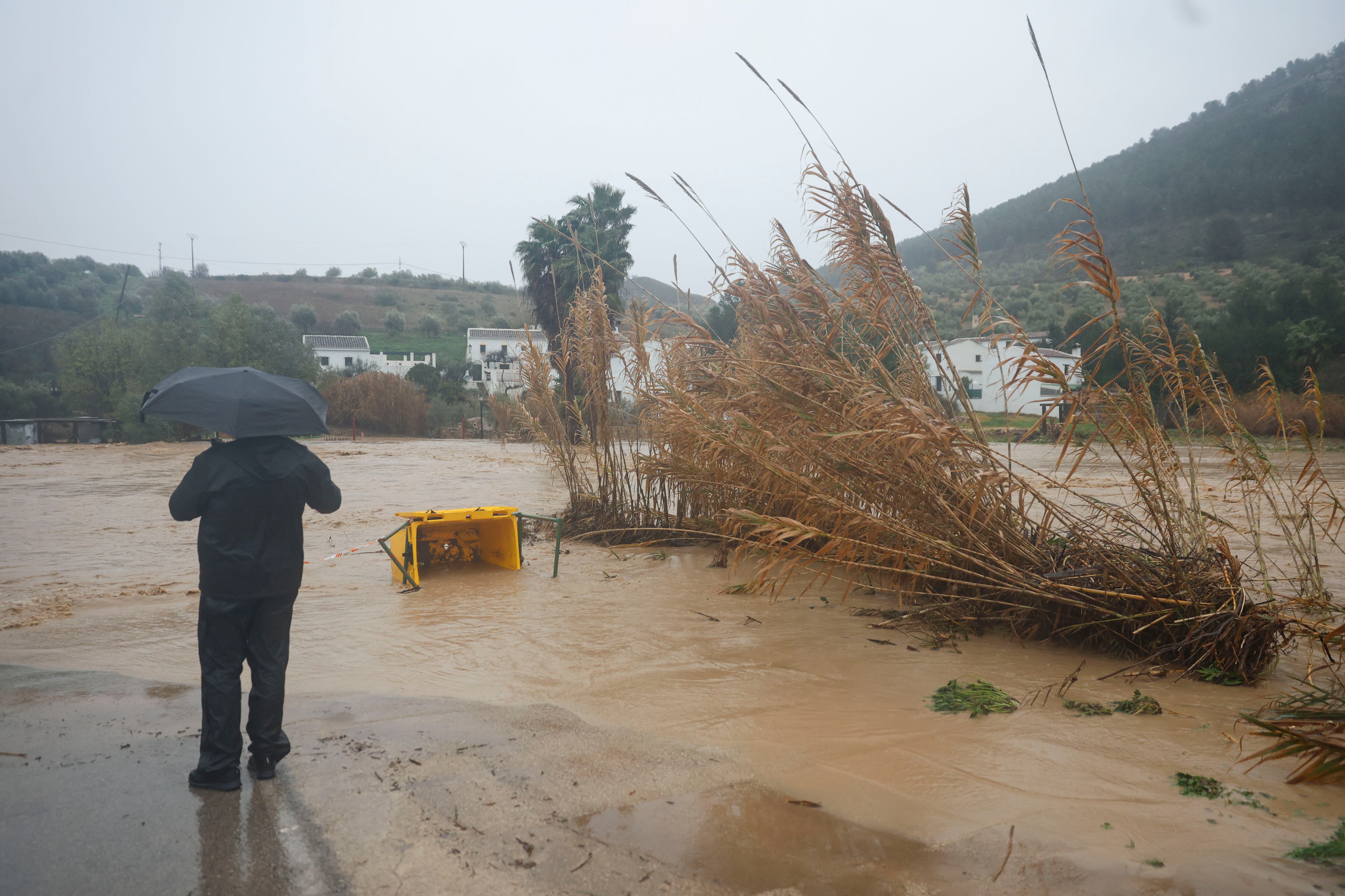 HUERTA DE LA CUEVA (MÁLAGA), 04/02/2026.- Un hombre junto a la carretera de acceso a Huerta de la Cueva, cortada este miércoles como consecuencia del paso de la borrasca Leonardo por la provincia de Málaga. EFE/ Jorge Zapata