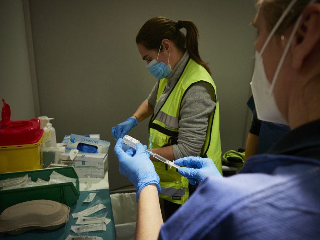 Dos trabajadoras sanitarias, en un dispositivo para administrar la vacuna contra la COVID-19 a profesionales sociosanitarios, en Pamplona, Navarra (España), a 29 de diciembre de 2020. Navarra ha comenzado este martes a vacunar frente al Covid-19 a los pro