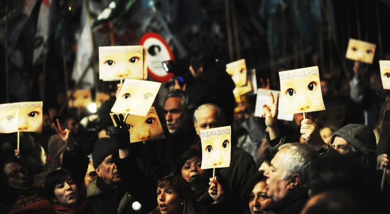 La gente escucha la sentencia contra los exdictadores argentinos de la última dictadura en Argentina por los robos de bebé en Comodoro en julio de 2012.