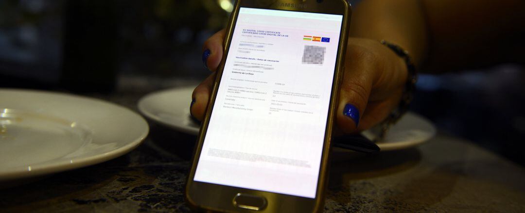 Archivo - Certificado digital de vacunación de una clienta de La Rioja en el casco histórico de Orense, a 24 de julio de 2021