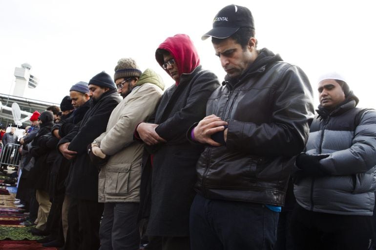Varias personas rezan durante la oración Yumu'ah de los viernes en el aparcamiento del Terminal 4 del Aeropuerto John F. Kennedy en Nueva York