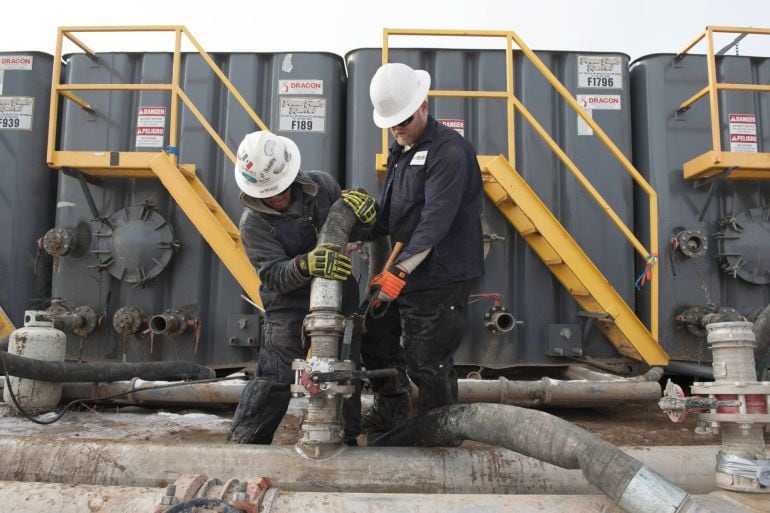 Dos operarios trabajan en una planta que utiliza el método de extracción de gas mediante el &quot;fracking&quot; o técnica de fracturación hidráulica. 