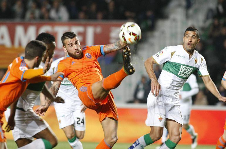 GRA418. Elche (ALICANTE), 20/03/2015.- El defensa argentino del Valencia, Nicolás Otamendi (2d), despeja el balón ante los jugadores del Elche, el delantero brasileño Jonathas Cristian (d), y el centrocampista caboverdiano Garry Mendes (2i), durante el encuentro correspondiente a la jornada vigesimo octava de primera división, que disputan esta noche en el estadio Martínez Valero de la localidad ilicitana. EFE / Morell.