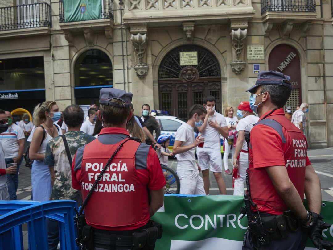 Agentes de la Policía Foral controlan la afluencia de gente en la Plaza del Consistorio en el momento en el que de celebrarse los Sanfermines 2020 hubiera tenido lugar el chupinazo, en Pamplona