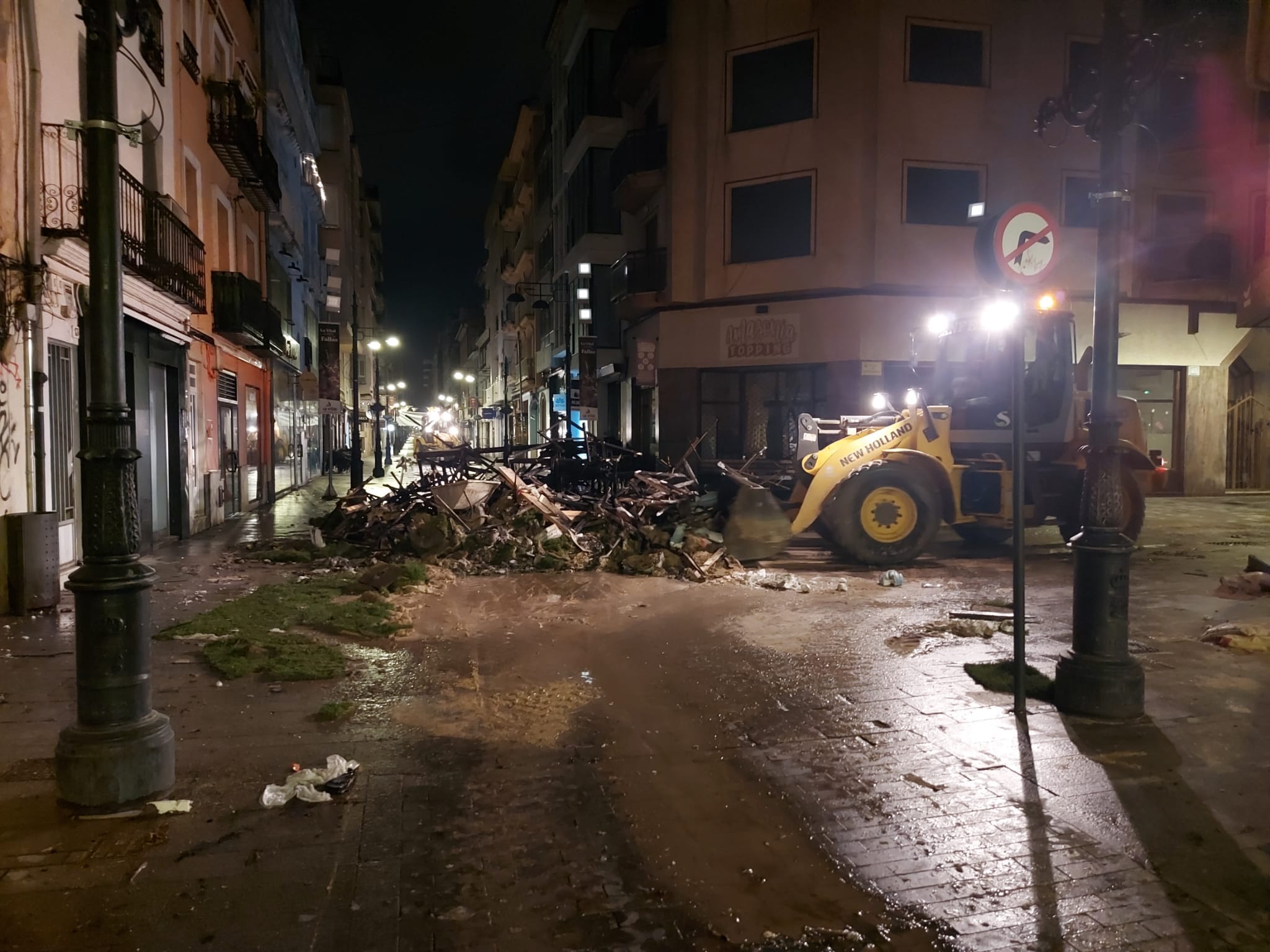 Los operarios retiran los restos de la falla Vilanova tras la Cremà en Gandia