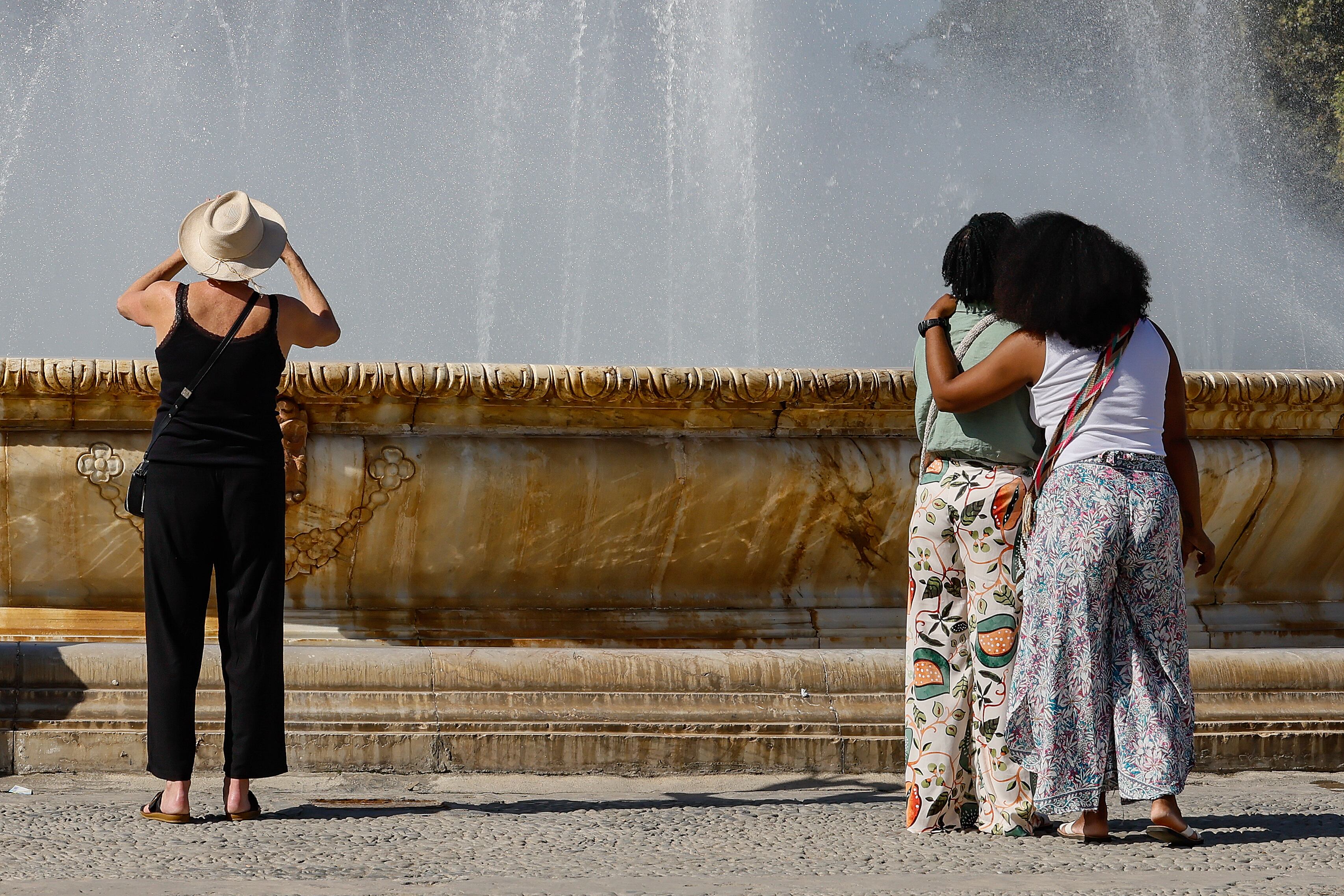 Unos turistas toman fotos en la plaza de España de Sevilla.