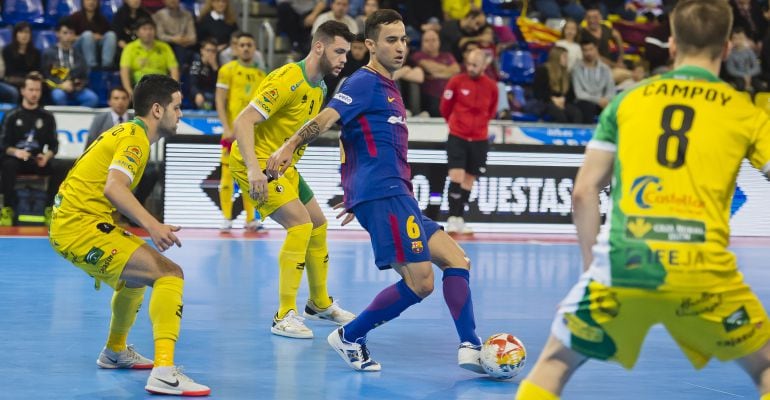 Varios jugadores del Jaén FS intentan frenar el avance de un hombre del Barcelona FS.