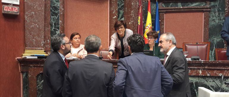 Los cuatro portavoces parlamentarios, hablando con la presidenta de la Asamblea Regional, durante una sesión plenaria de la Cámara.