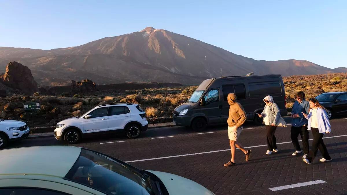 LA OROTAVA (TENERIFE), 02/02/2024.- La presión demográfica sobre el Teide, que el 22 de enero ha celebrado el 70 aniversario de su declaración como parque nacional, es “muy fuerte” en espacios concretos y limitados pero, sin embargo, hay esperanza para el 80 % de su superficie, salvada por una estructura geológica no caminable. En la imagen, cuatro personas caminan junto a varios vehículos por el parque nacional. EFE/Alberto Valdés