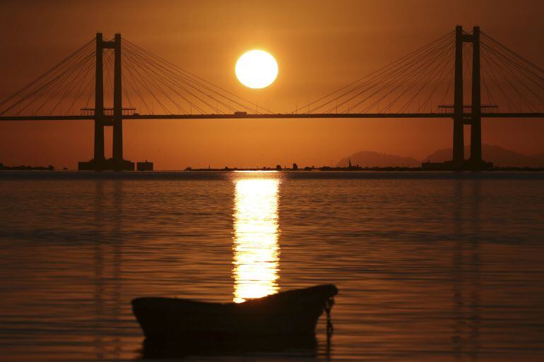 Vista de la puesta de sol en la Ria de Vigo desde la playa de Cesantes en el último domingo de noviembre, que se despide en Galicia con cielos despejados y temperaturas que han llegado a una maxima de nueve grados.