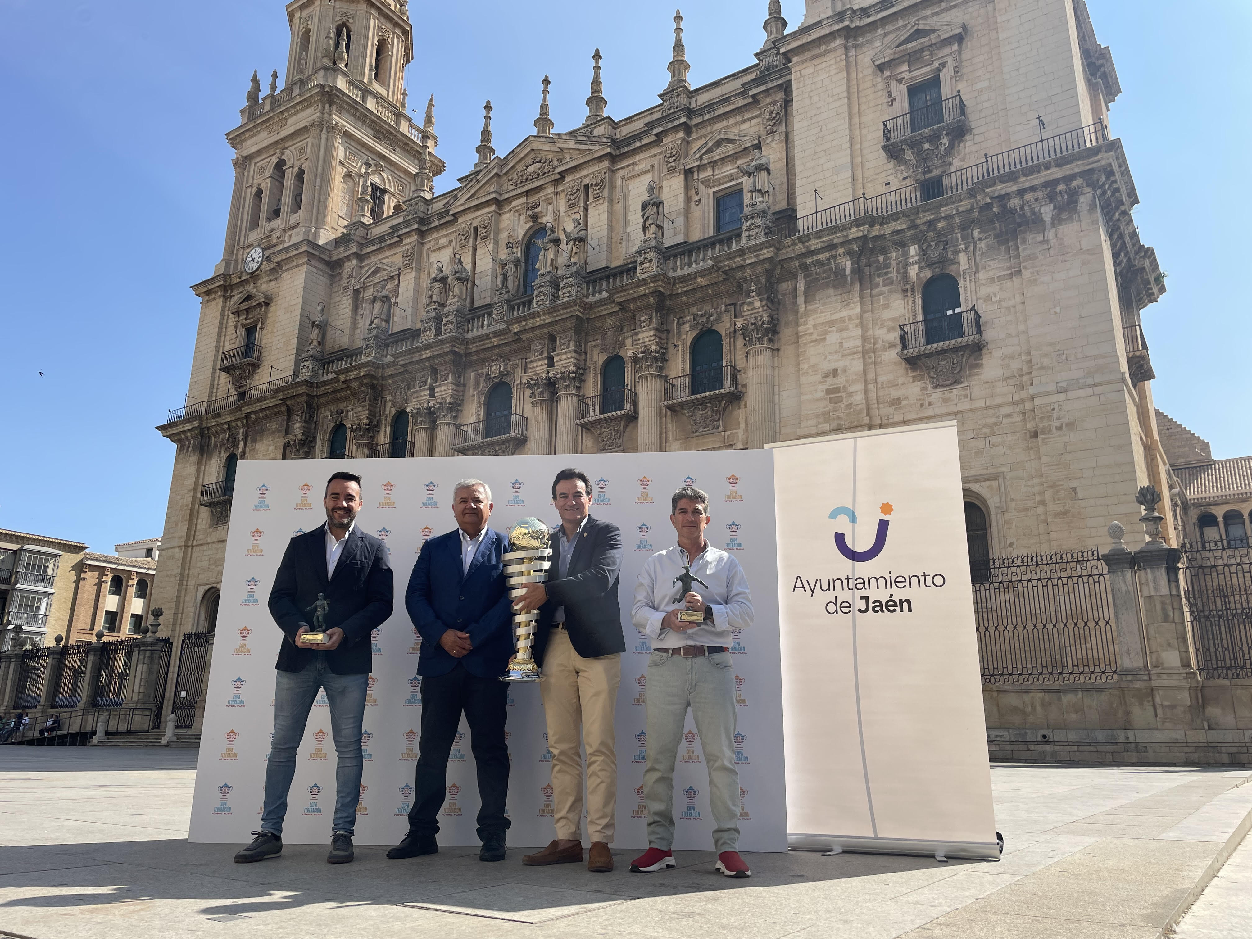 El concejal de Deportes, José María Álvarez, el presidente delegado de la Real Federación Andaluza de Fútbol en Jaén, Javier Mañas, y el presidente de la Comisión Nacional de fútbol playa, Diego Martínez, han presentado la Copa Federación de este deporte en la plaza Santa María, junto al alcalde Agustín González.