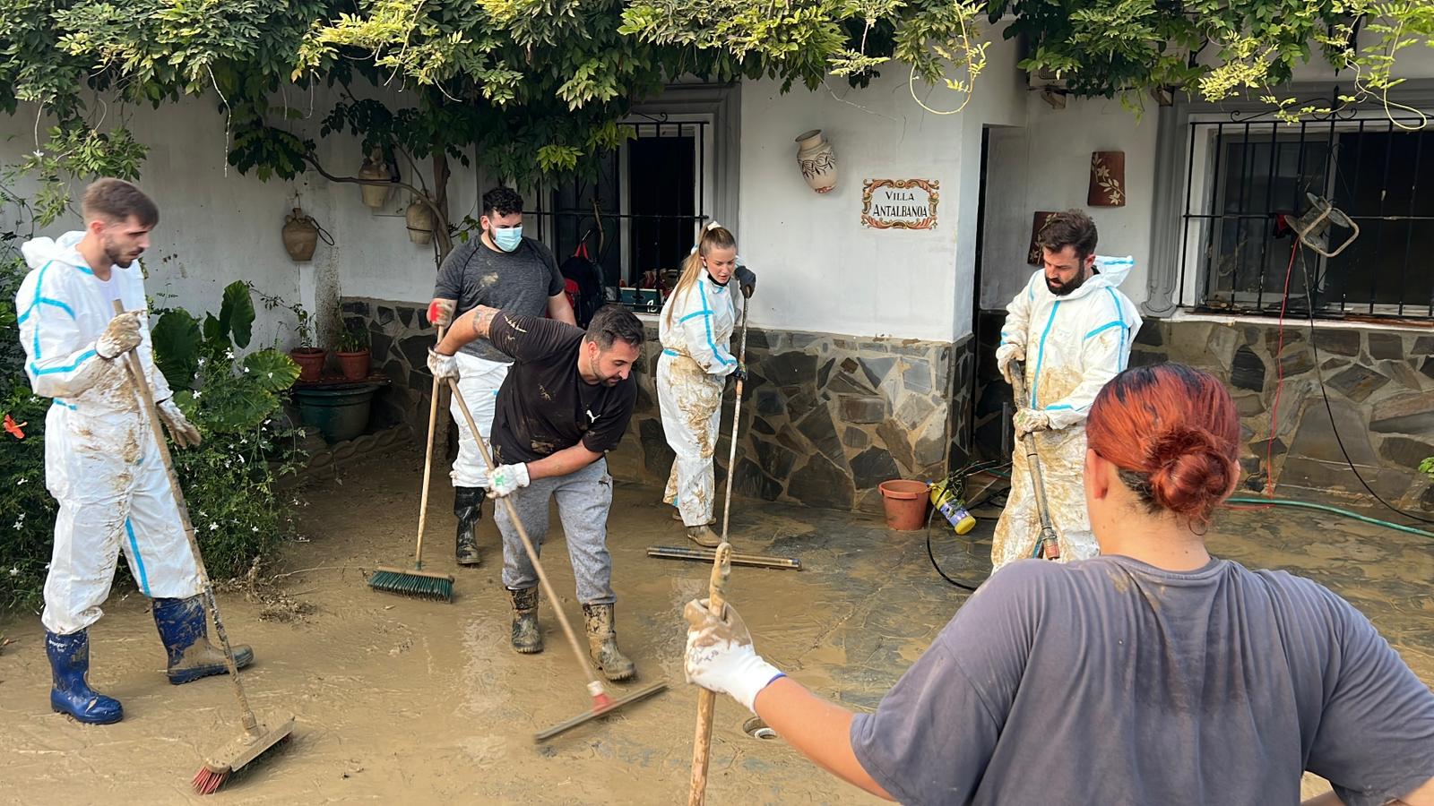 Voluntarios durante las tareas de limpieza estes lunes en la barriada Doña Ana de Cártama (Málaga)