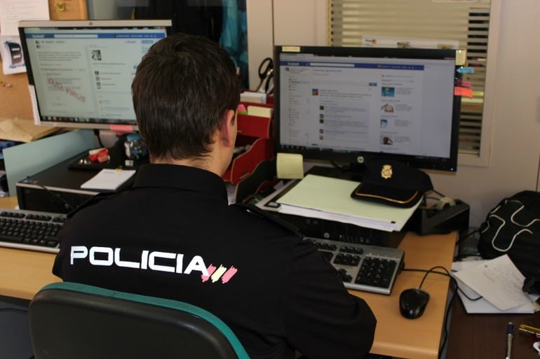 Un agente de la policía nacional restreando redes sociales