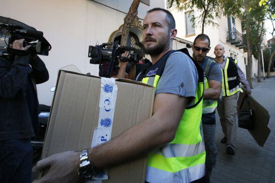 Spanish police officers carry boxes of evidence from the residence of Oleguer Pujol, son of former president of Catalonia Jordi Pujol, after he was detained as part of an investigation by a High Court examining judge for tax fraud and money laundering in 