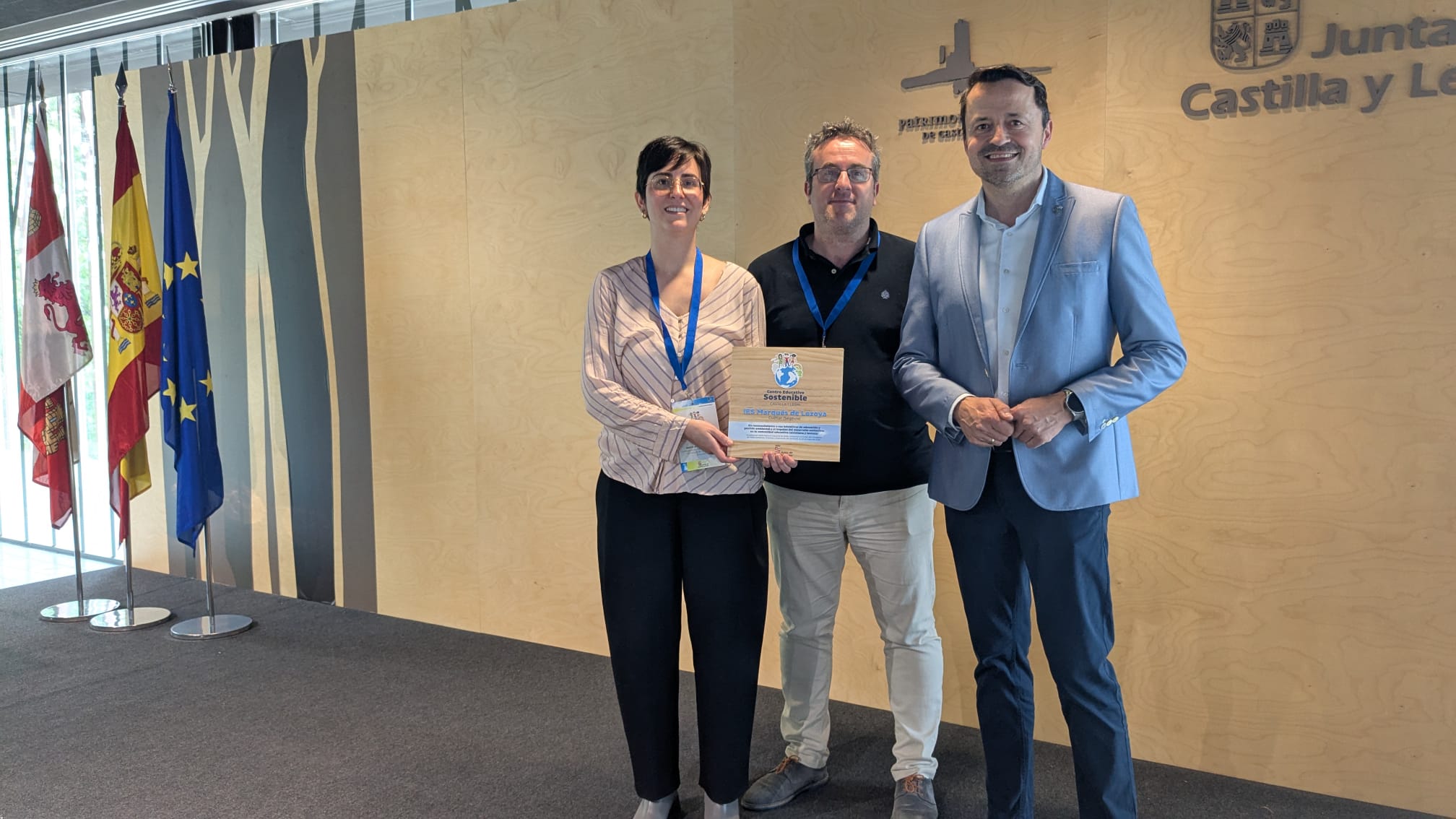 Marta Senovilla coordinadora del proyecto, César Alonso, director del IES Marqués de Lozoya y Diego del Pozo, director provincial de Educación, muestran el sello ambiental que se otorga al IES Marqués de Lozoya de Cuéllar