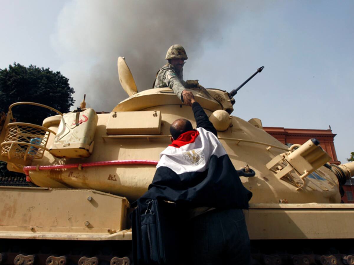 Un manifestante saluda a un soldado en El Cairo