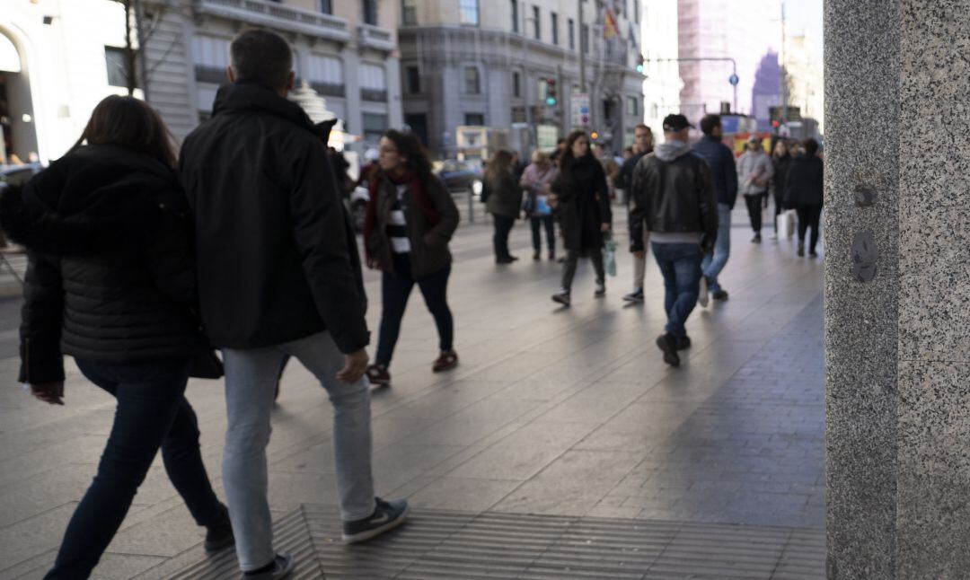 Unos jóvenes pasean por el centro de Madrid.