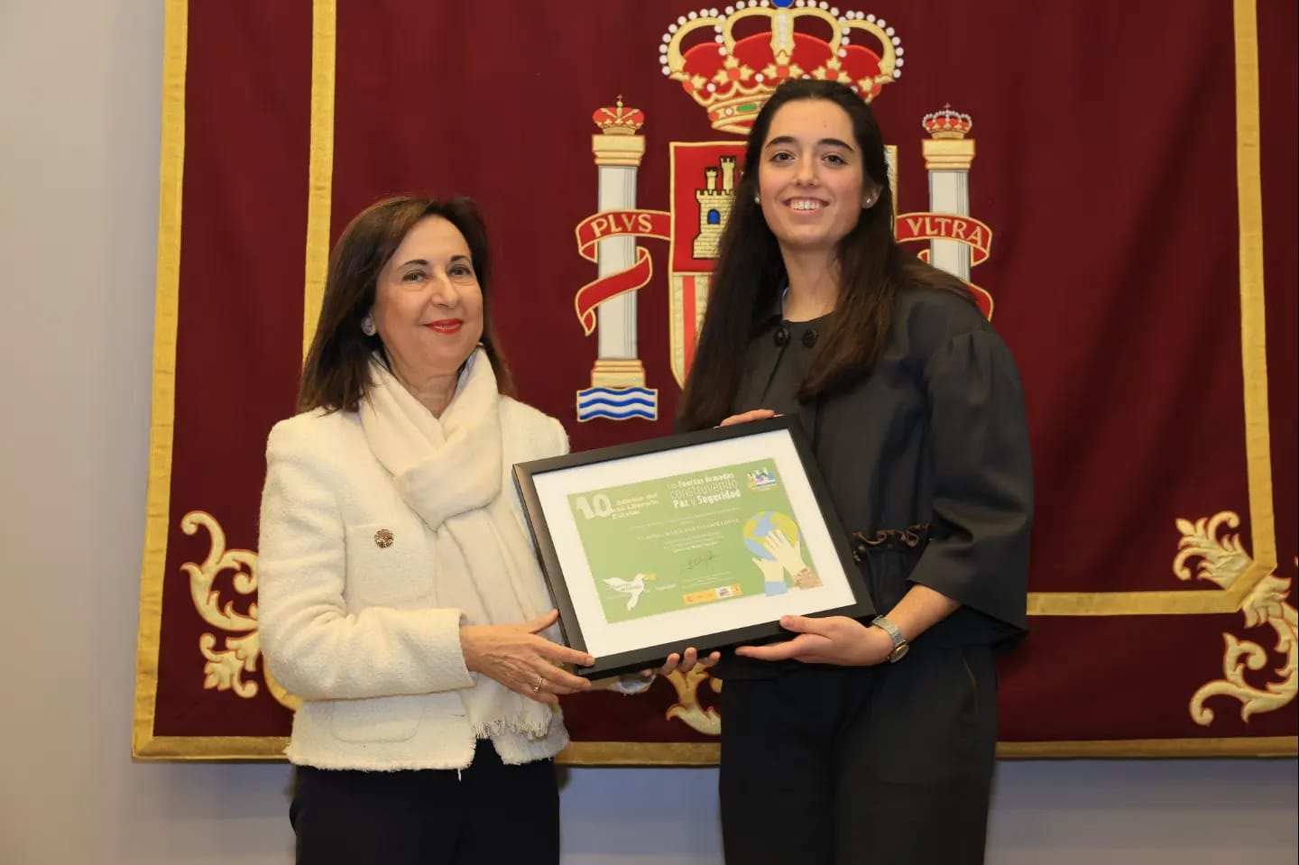 La ganadora del certamen literario, Claudia María Bartolomé, recibe el premio de manos de la ministra Robles