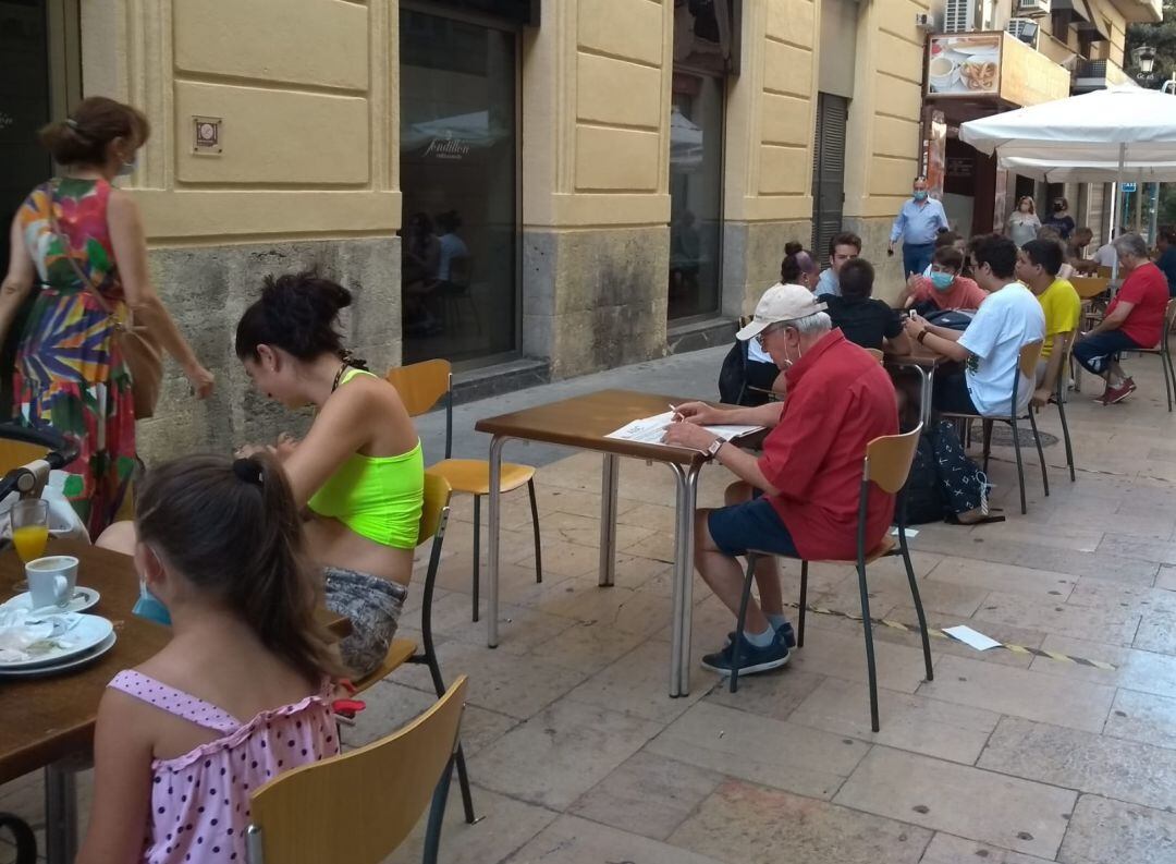 Un hombre fuma en la terraza de un bar en una céntrica calle de Alicante, en el primer día de las nuevas restricciones ante la COVID-19