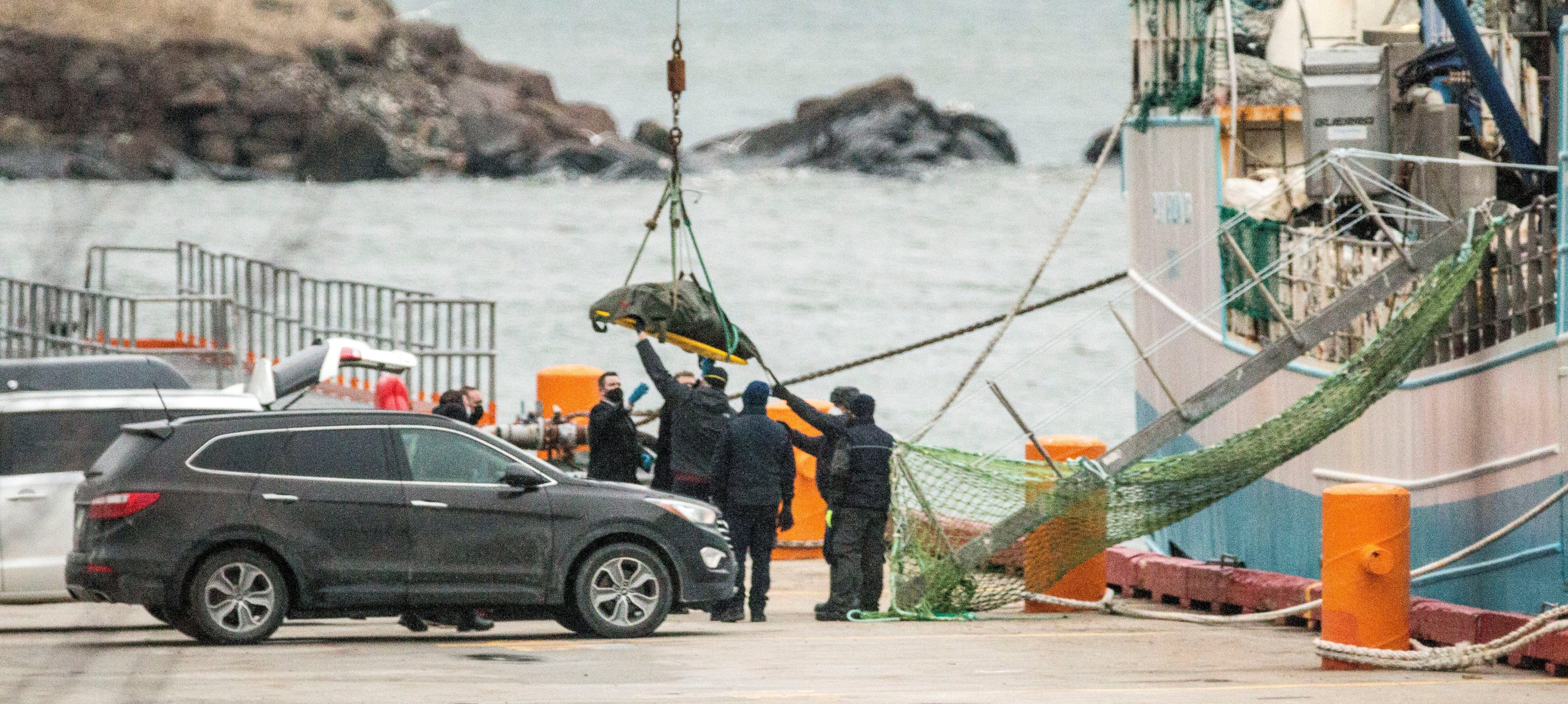 Trabajadores de una empresa funeraria recogen el cuerpo de uno de los tripulantes del Villa de Pitanxo en el puerto de San Juan de Terranova. EFE/Julio César Rivas