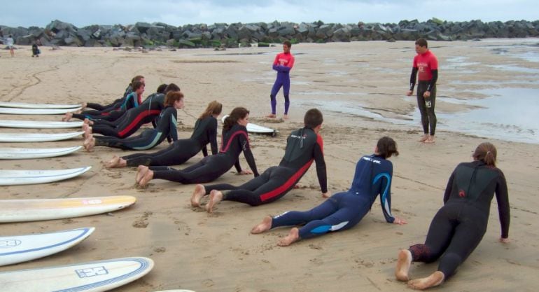 Alumnos reciben clases de surf en la playa de la Zurriola