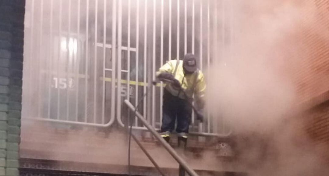 Operario municipal realiza tareas de limpieza en la entrada del Mercado de San Francisco en Jaén capital.