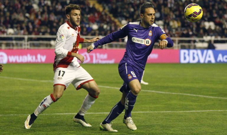 El delantero del Espanyol Sergio García protege un balón ante Quini, del Rayo Vallecano.