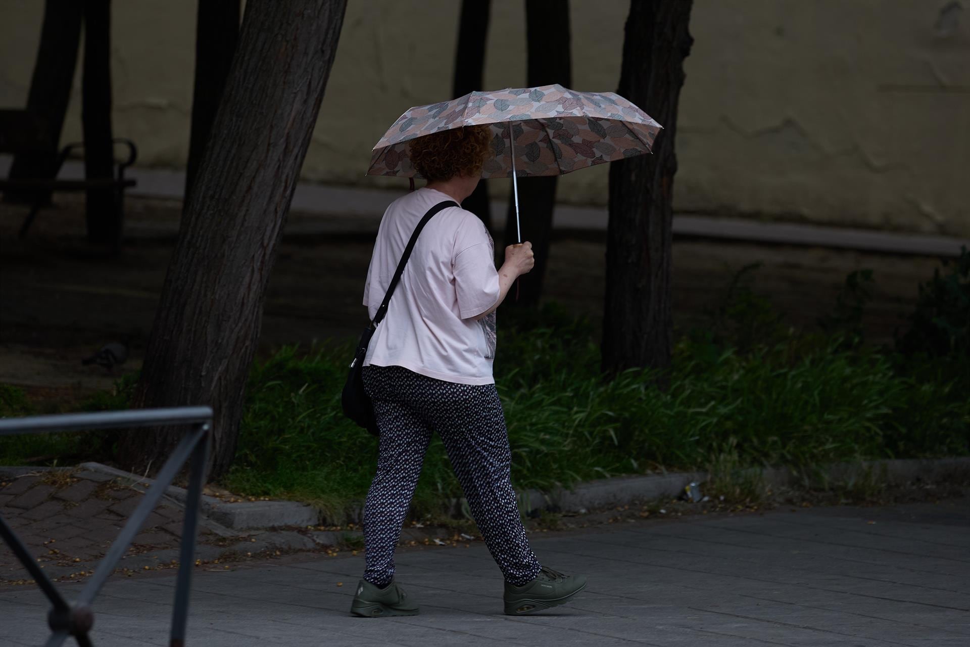 Una mujer se protege de la lluvia